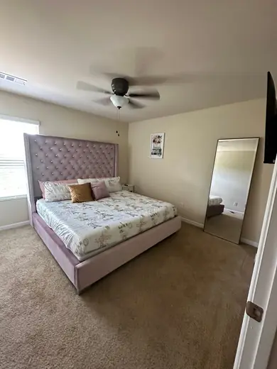 Cozy bedroom with plush bed at Luxury Living Recovery, a sober living home in Atlanta.