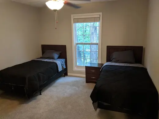 Cozy bedroom with two beds at Freedom Arch, a sober living home in Atlanta.